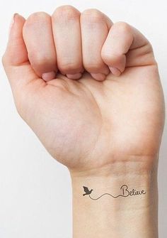 a woman's arm with a small tattoo on it that says believe and a bird