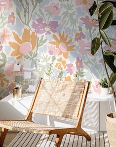 a wooden chair sitting on top of a hard wood floor next to a flower covered wall