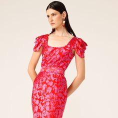 The Firebird Dress embodies Autumn elegance and brings a pop of colour to the darker months. Made from a lightweight silk rayon burnout fabric, the ankle length dress features draped cap sleeves in a bias cut fitted silhouette that finishes in a slight mermaid hem. It is the perfect party piece for a formal occasion. We will be wearing bright accessories to bring out the gorgeous pink red floral print!   Lightweight silk rayon burnout fabric  Bodice lined in satin  Draped cap sleeves for added a Spring Pre-draped Fitted Maxi Dress, Fitted Silk Maxi Dress With Square Neck, Fitted Pre-draped Maxi Dress For Summer, Fitted Pink Maxi Dress With Draped Sleeves, Festive Fitted Dress With Draped Sleeves, Summer Dress With Draped Sleeves And Fitted Bodice, Fitted Red Dress With Draped Sleeves, Festive Fitted Pink Midi Dress, Fitted Pink Midi Dress For Festive Occasions