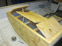 an unfinished boat is being built on the back of a boat in a workshop area