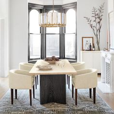 a dining room table with chairs around it and a chandelier hanging from the ceiling