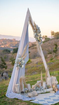 an outdoor wedding setup with white flowers and feathers