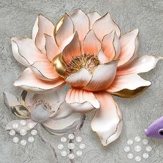 there is a flower on the wall next to a fish and some pearls in front of it