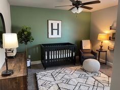 a baby's room with green walls and furniture