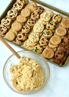 a cookie tray filled with cookies and sprinkles next to a bowl of oatmeal