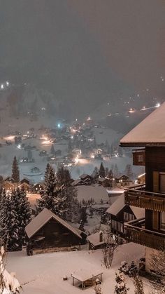 a snowy mountain town at night with snow on the ground and lights in the sky