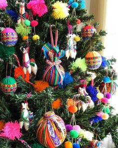 a christmas tree decorated with brightly colored ornaments and pom - poms on it