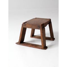 an old wooden stool sitting on top of a white floor