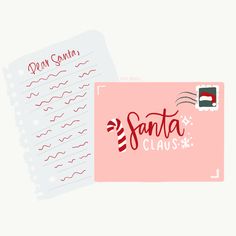 a pink santa clause envelope with the word santa claus written on it next to a pile of paper