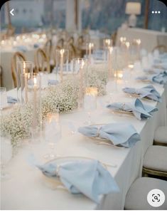 the table is set with candles, flowers and napkins for an elegant wedding reception