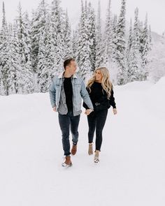 a couple walking through the snow holding hands