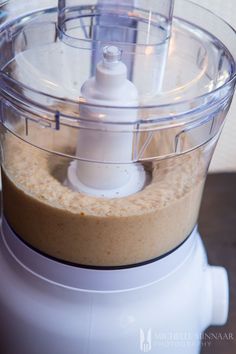 a food processor filled with brown liquid on top of a table