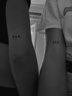 two people with small tattoos on their arms, one is showing the number four and the other