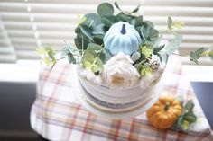 there is a cake with flowers and pumpkins on the table