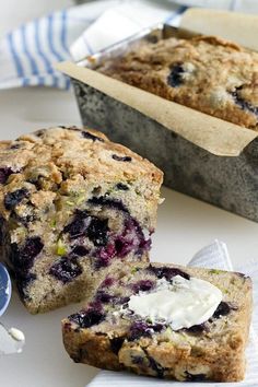 blueberry muffins with butter on top sitting next to a loaf of bread