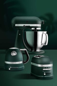 three different types of kitchen appliances on a green surface with one being a mixer and the other is an appliance