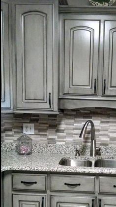 a kitchen with gray cabinets and granite counter tops