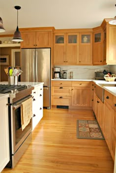 a kitchen with wooden floors and white cabinets