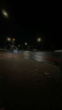 an empty parking lot at night with street lights