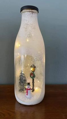 a glass bottle filled with snow and lights