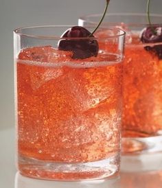 two glasses filled with ice and cherries