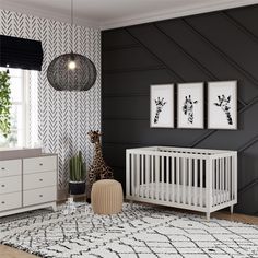 a baby's room with black and white wallpaper, a crib, two framed pictures, and a giraffe