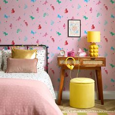 a bedroom with pink wallpaper and yellow accents