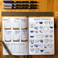 an open notebook with coffee and sweaters drawn on it, next to pencils