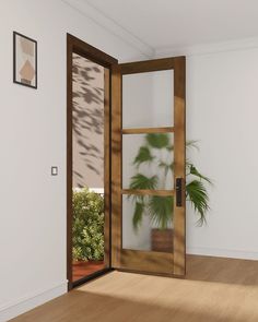 an empty room with a potted plant in the corner and a glass door to another room