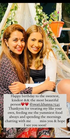 two women sitting next to each other in front of a sign that says happy birthday to the sweetest kindie & the most beautiful friend