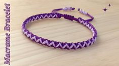 a purple and white braided bracelet sitting on top of a wooden table next to a star