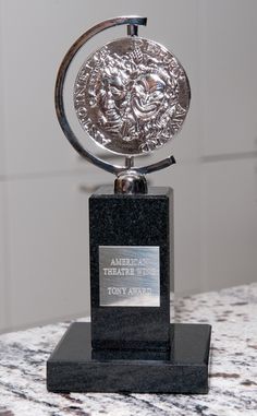 a silver trophy sitting on top of a marble counter