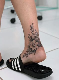 a woman's foot with a flower tattoo on it