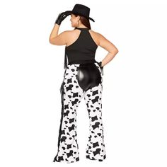 a woman in cow print pants and black hat with her back to the camera, wearing a