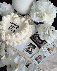 there is a wedding cake on the table with flowers and pictures next to it,