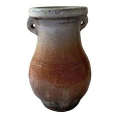 a brown and white vase sitting on top of a table