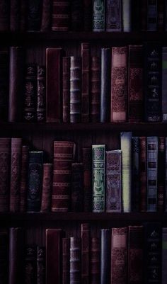 a book shelf filled with lots of books on top of wooden shelves next to each other