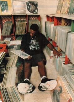 a man sitting on the floor surrounded by records