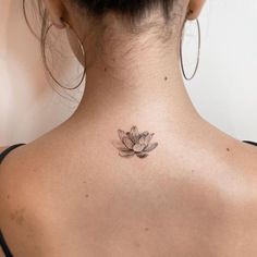 the back of a woman's neck with a lotus tattoo on it