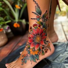 a woman's foot with flowers and leaves on the bottom part of her leg