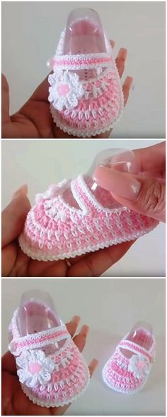 crocheted baby shoes with pink and white trims are being held by someone's hand