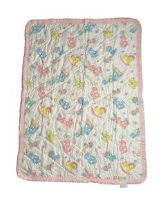 a baby blanket with teddy bears and hearts on the front, in pastel colors