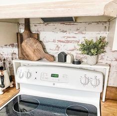 a stove top oven sitting inside of a kitchen next to a wooden counter and white cabinets