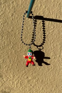 a keychain with a clown figure hanging from it's side on a beach