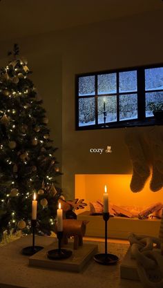 a living room with a christmas tree and lit candles