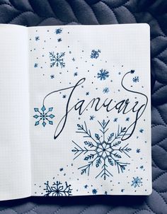 an open notebook with the word january written in cursive writing and snowflakes