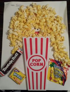 popcorn, candy and other snacks are sitting on a paper bag with the word pop corn in it