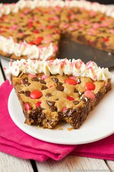 a slice of chocolate chip cookie pie on a white plate with a pink napkin next to it