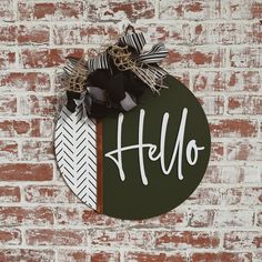 a sign that says hello hanging on a brick wall