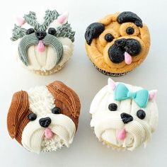 four cupcakes with dog faces on them, one is white and the other is brown